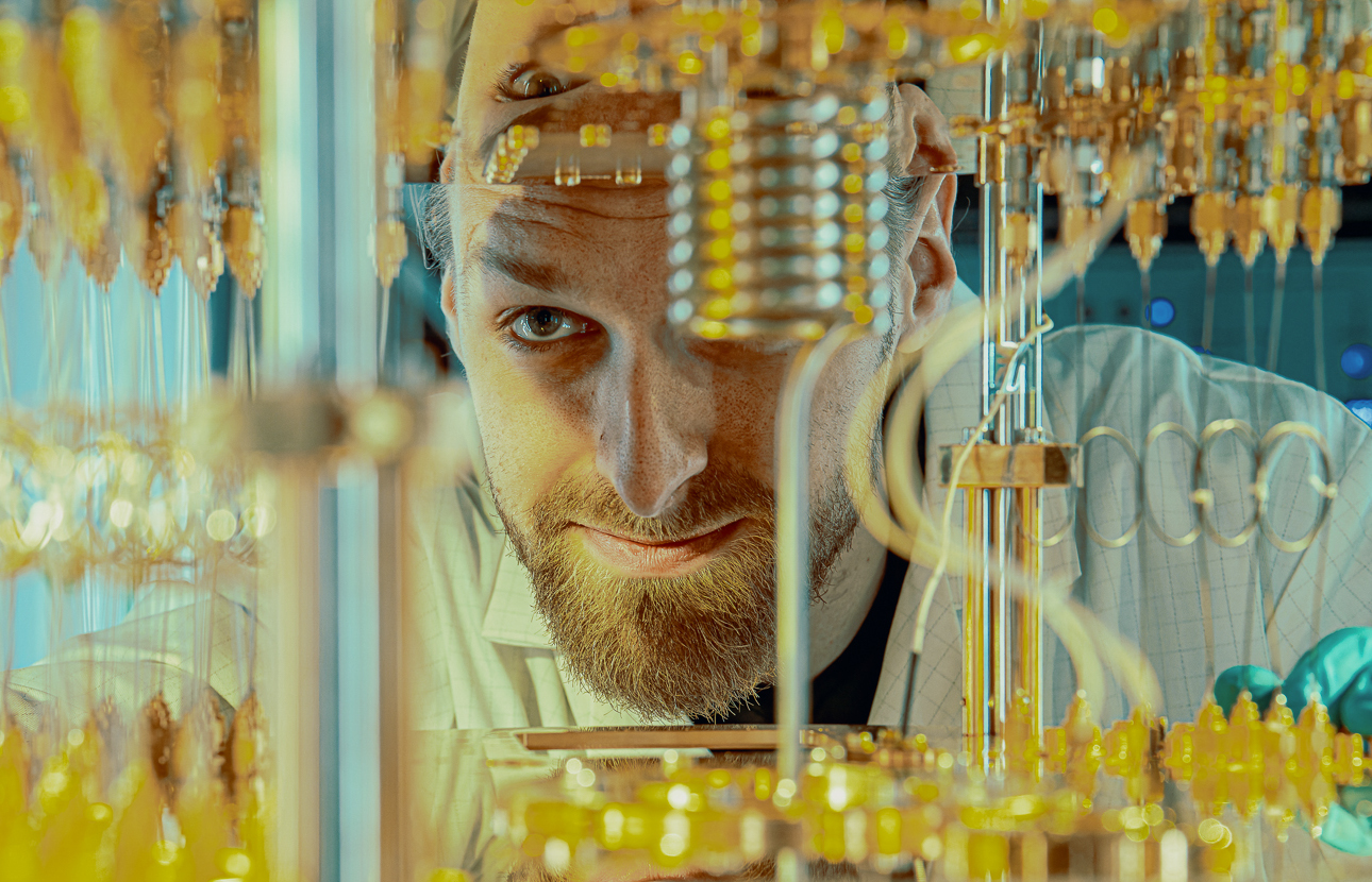 Vladimir Milchakov next to a superconducting quantum computer at IQM Quantum Computers